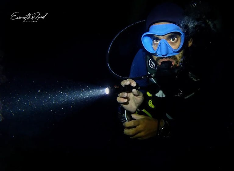 Advanced Scuba diver diving with a torch during a night dive at Gili Trawangan