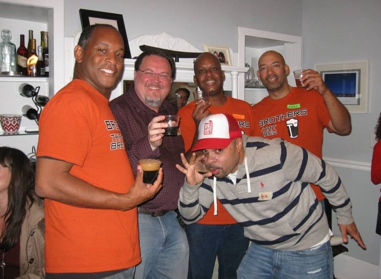 A group of friends smiling and drinking craft beer at a home tasting event.