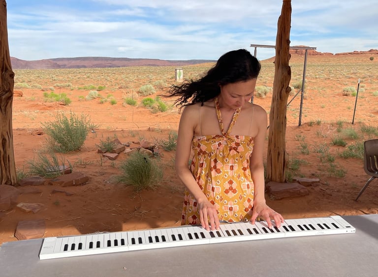 Composer Jen Smith Lanthier in the Arizona desert playing a piano keyboard