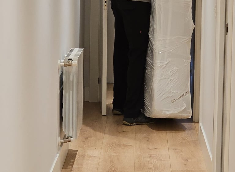 a man is moving a mattress in a hallway