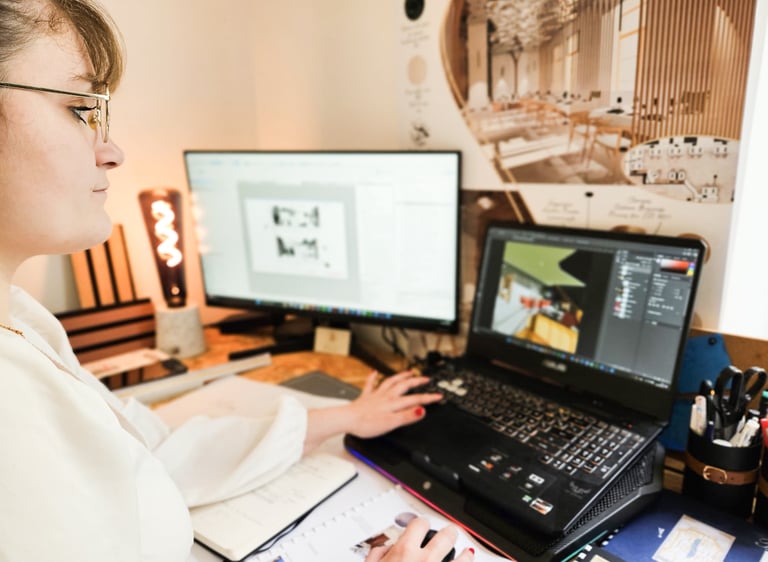 a woman sitting at a desk with a laptop and a notebook