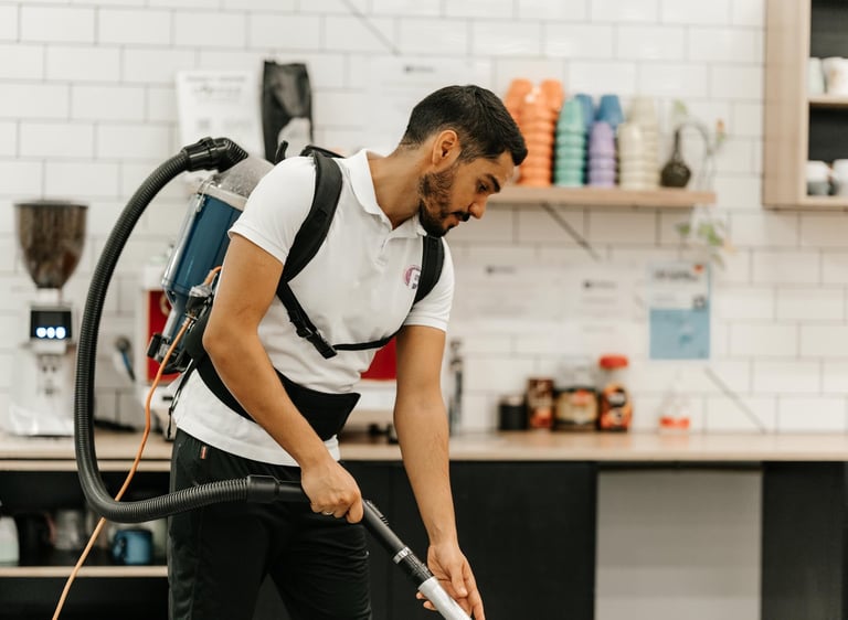 a man in a white shirt is cleaning a kitchen
