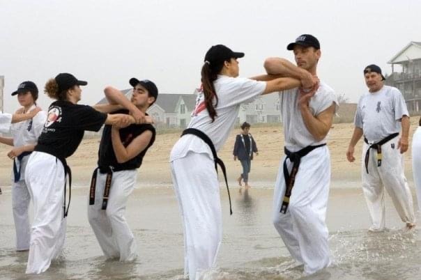 a group of people standing in the water practicing self defence