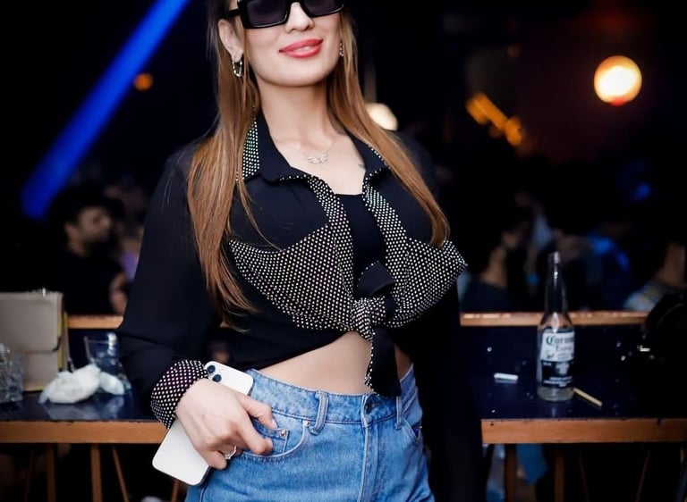 a woman in a black top and shorts with sunglasses