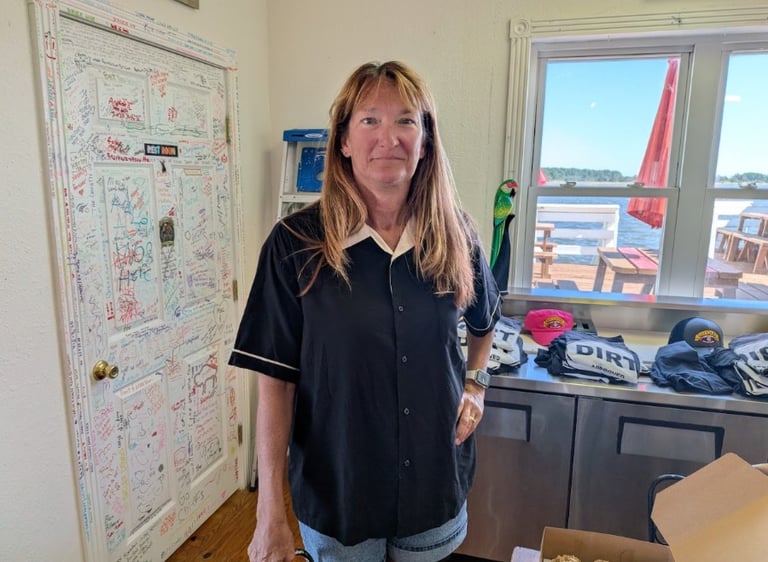 Ellen standing in front of a table with t-shirts on it