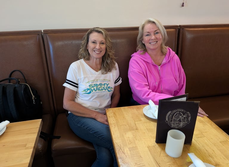 women seated in a booth at obx brewing station