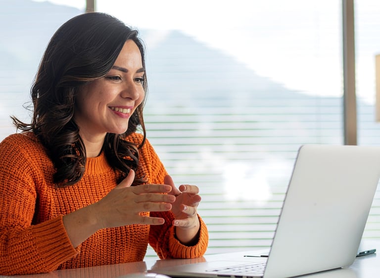 a woman sitting at a desk with a laptop