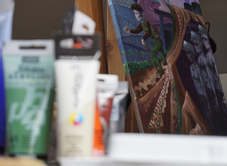 A painted canvas in a cubist or constructivist style depicting agriculture is displayed in focus.
