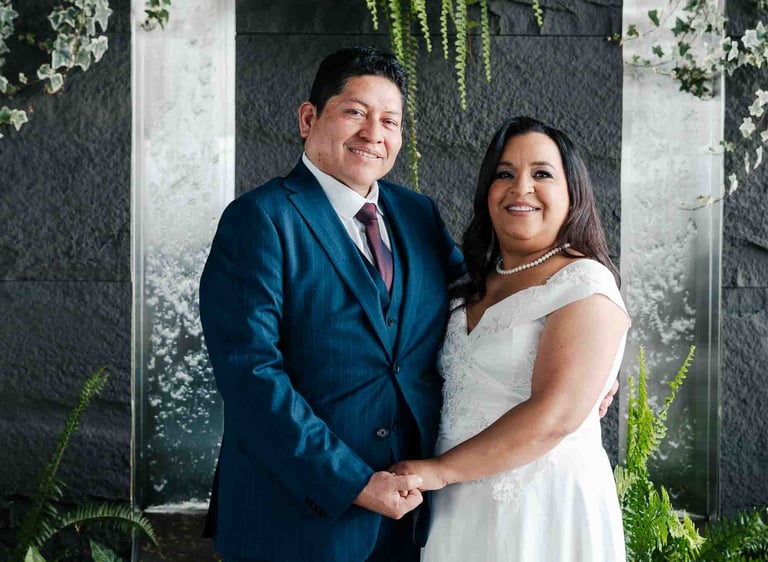 Retrato de bodas de recién casados tomados de la mano en un espacio elegante con plantas y cascadas en Quito Ecuador