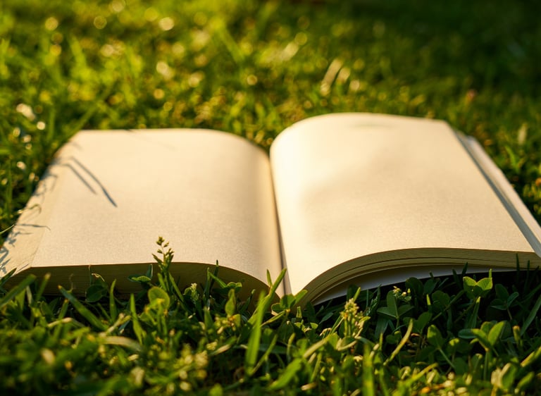 Aufgeschlagenes Buch auf einer gruenen Wiese mit Trauerrede