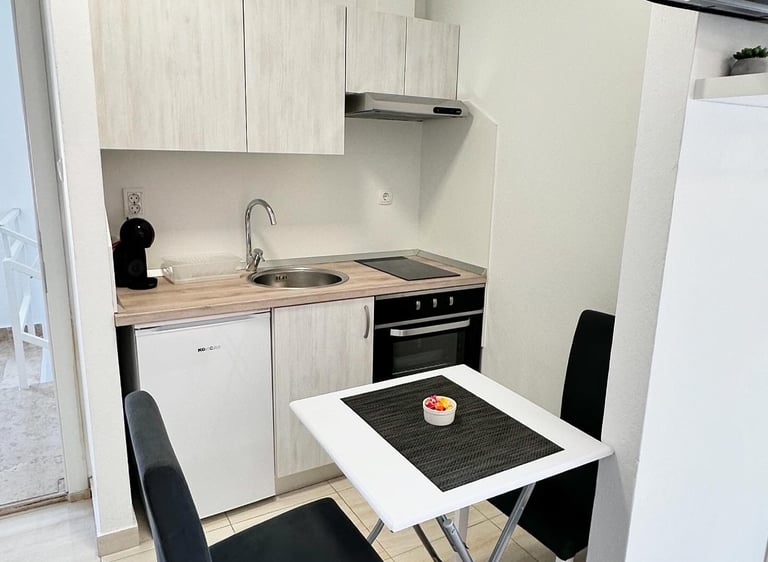 kitchen with coffe machine, fridge table and chairs