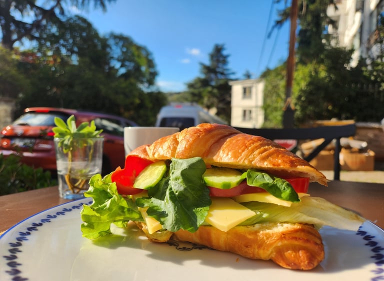 bir tabak üzerinde domates salatalık peynirden oluşan kruvasan sandviç