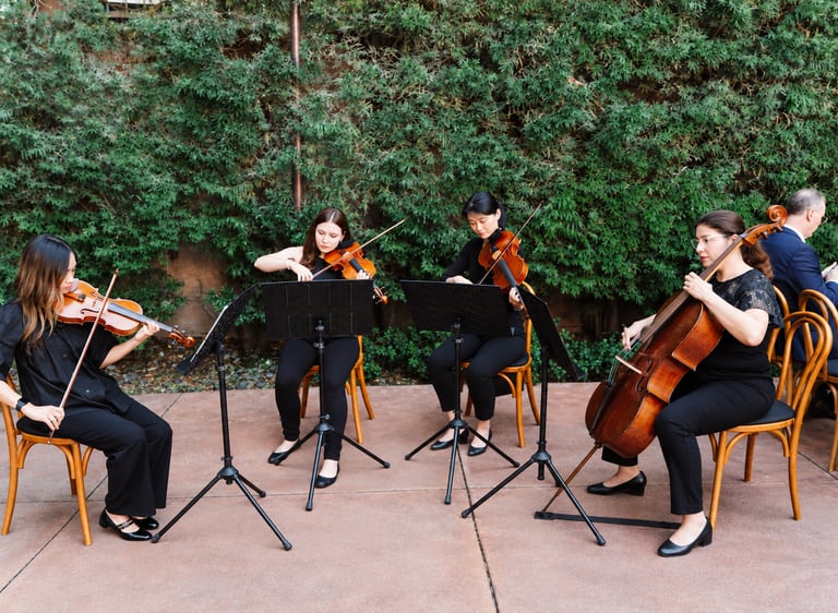 A wedding string quartet performs outdoors at a wedding at Franciscan Gardens in San Juan Capistra