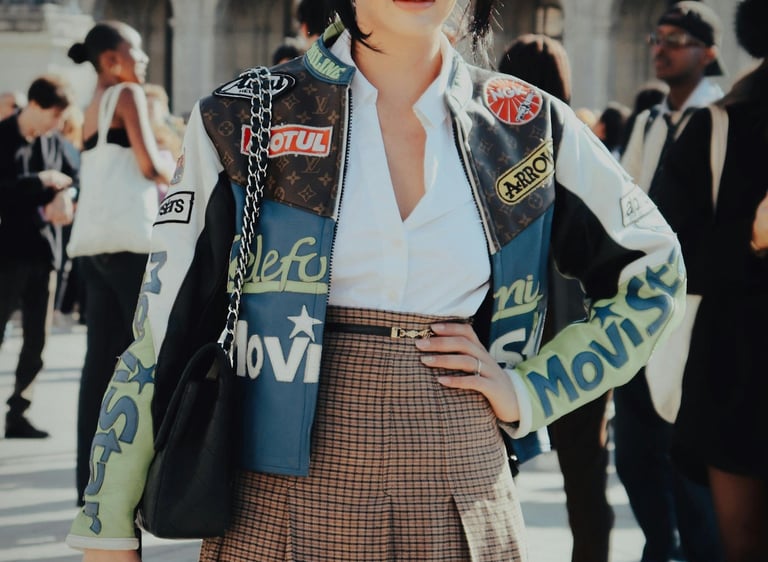 une femme à la fashion week qui porte une verte en cuir avec des patchs