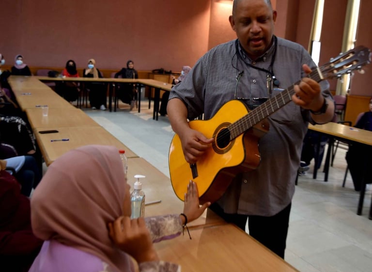 Former UN official Bruno Donat playing guitar with deaf women in Gaza, Palestine