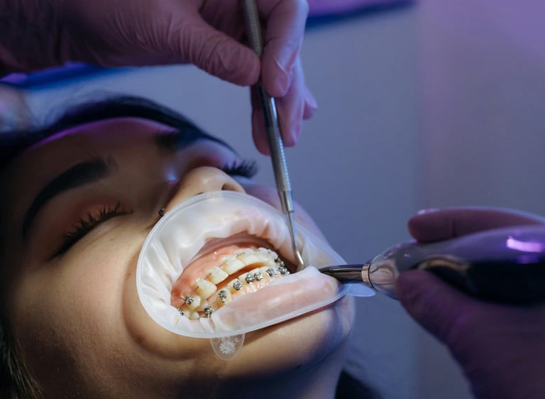 Orthodontist adjusting metal braces on a patient's teeth using professional dental tools.