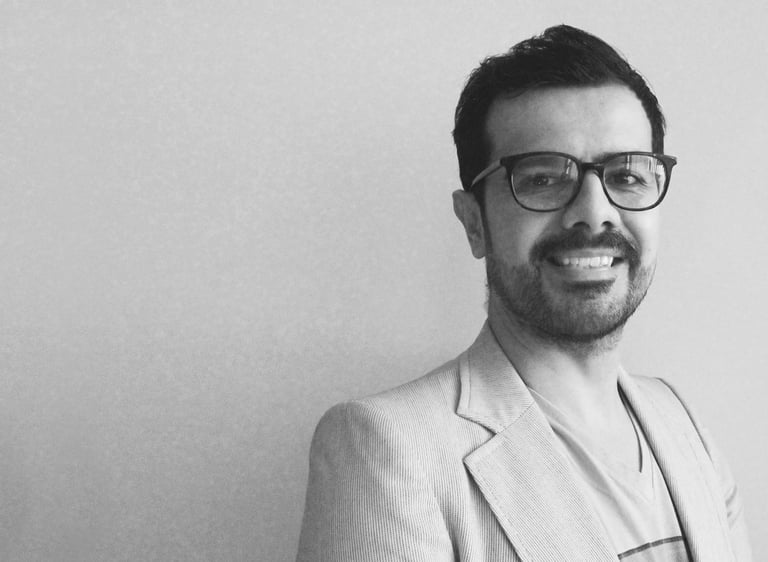 a man in a suit and glasses smiling