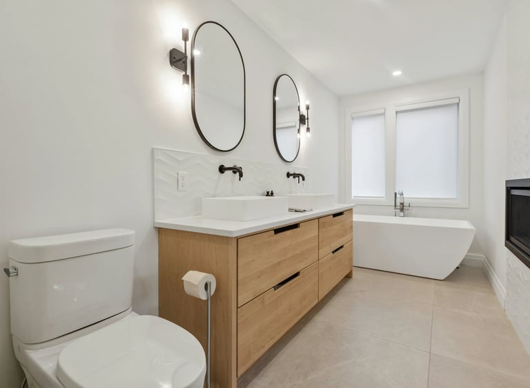 Salle de bain sur mesure avec meuble double vasque en bois clair et baignoire îlot conçue par Baïa Home à Caen