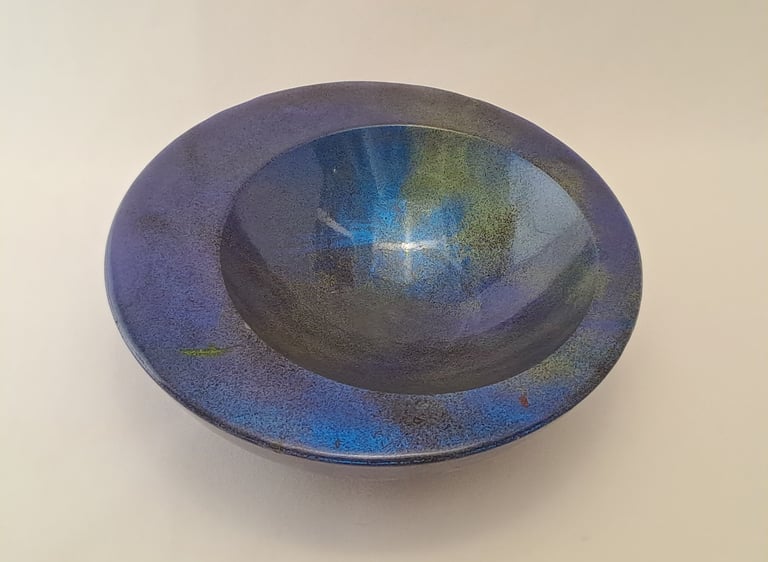 Handcrafted round gypsum bowl with a metallic iridescent blue and green glaze finish.