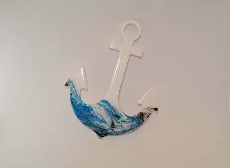 A white decorative wall anchor featuring a blue and black resin ocean wave pour art design.