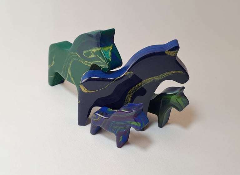 Handcrafted blue and green gypsum and resin horse figurines with northern lights design.