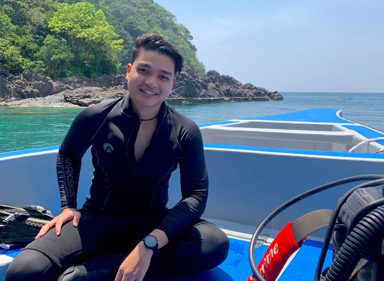 a man in a wetsuit sitting on a boat