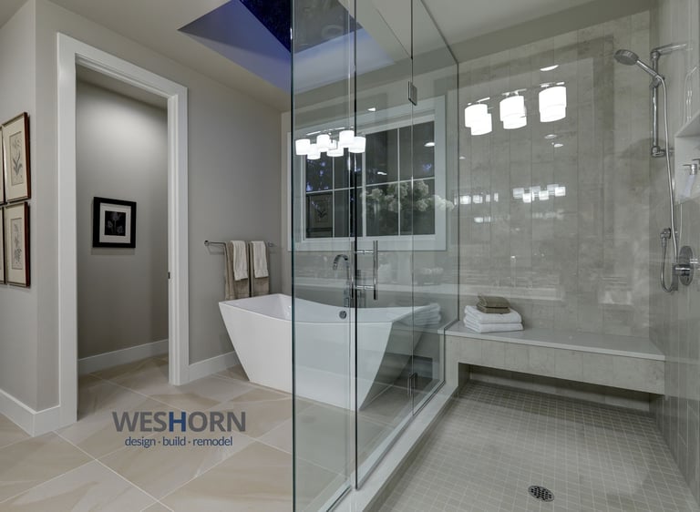 Modern luxury master bathroom featuring a freestanding soaking tub and a spacious glass-enclosed walk-in shower.