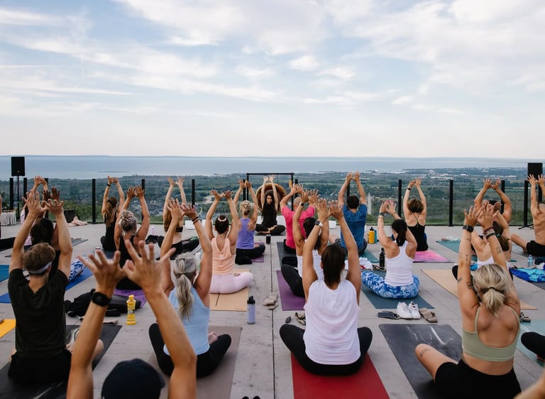 A group of people practicing outdoor yoga in  a wellness festival event