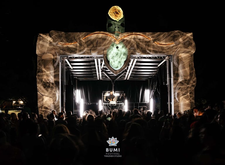 DJ on stage at Bumi Festival with a large stage decor and project mapping