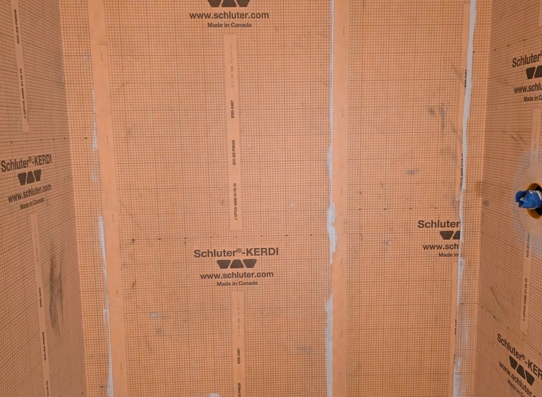 Schluter Kerdi waterproofing membrane installed on shower walls and floor for tile preparation.