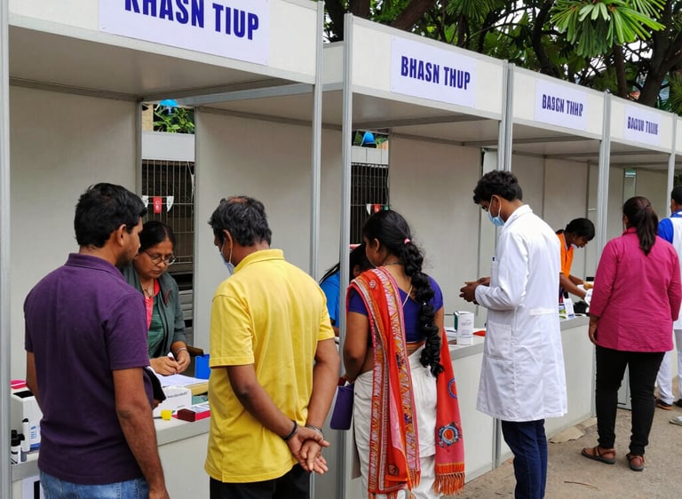 Health stalls with volunteers distributing support materials to attendees.