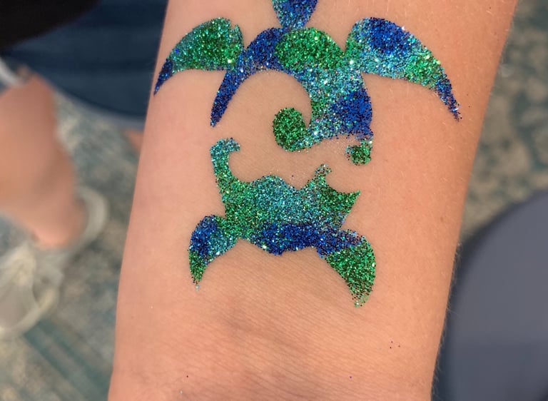 sea turtle glitter tattoo on skin with glitter colors of blue, aqua, and green