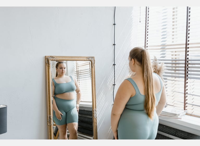 Femme en surpoids qui se regarde dans un miroir. 