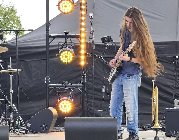 Camus playing bass at a live outdoor show