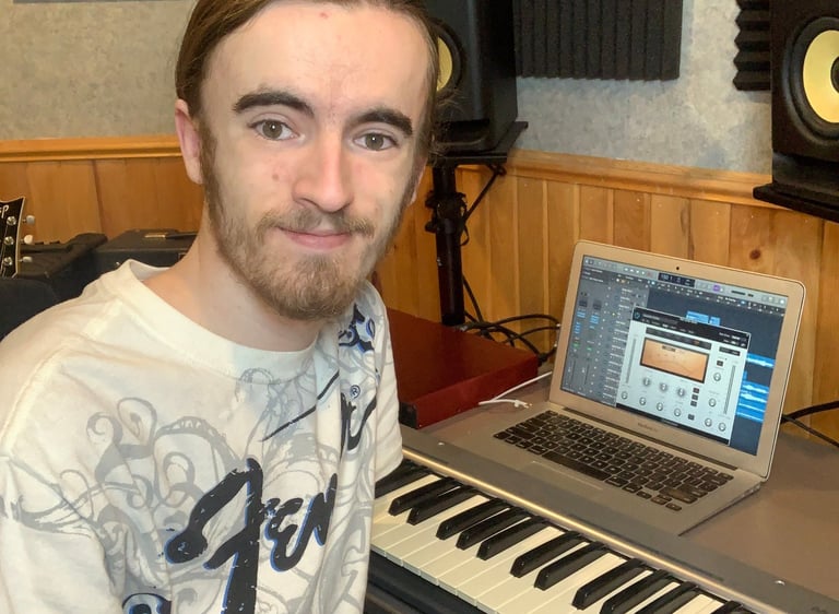 Camus Smiling at the camera while sitting at the desk at music man studios