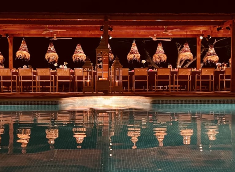 Poolside themed dinner under illuminated wooden pergola