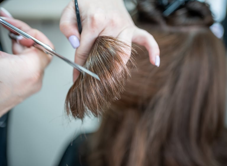 Haircut close-up with scissors and brown hair
