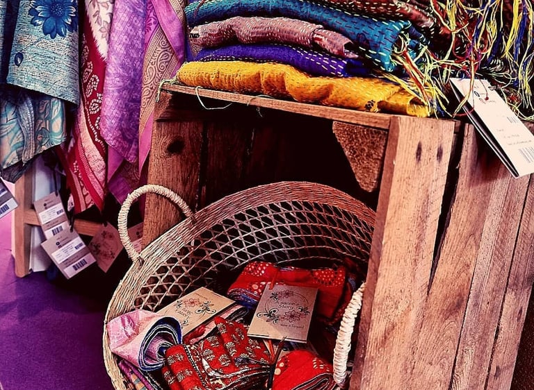 Folded vintage Indian sarees stacked in warm, earthy tones.
