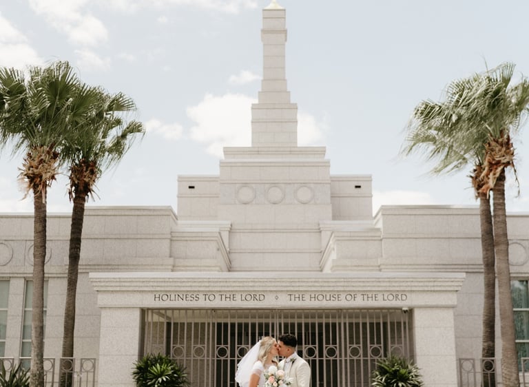 a bride and groom standing in front of a temple
