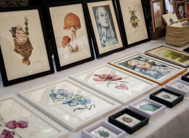 Multiple watercolor paintings displayed inside an art exhibition.