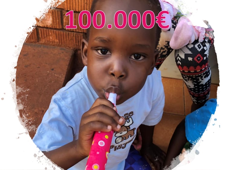 Kind aus Uganda mit Tröte im Mund und der Zahl 100.000