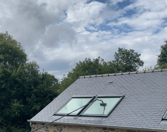 Nettoyage de Velux sur toiture avec système d’eau pure, pour un résultat net et sans traces.