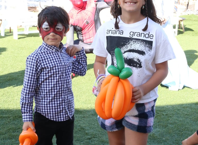 Kids posing with a pumpkin balloon