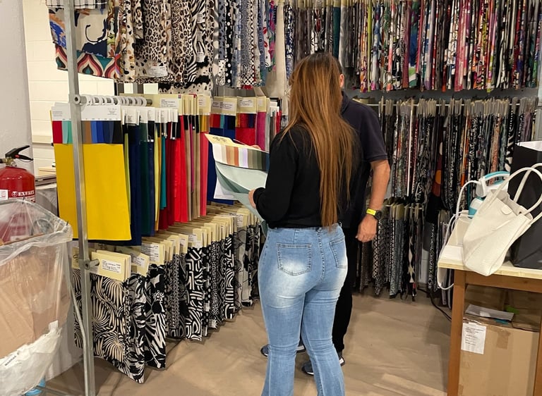 a woman standing in a room with a lot of clothes