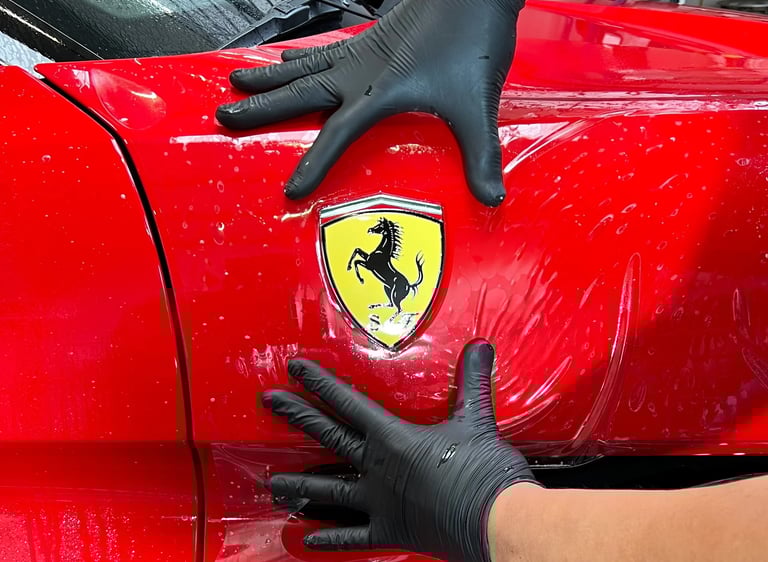 Installation d'un PPF sur le bloc avant d'une Ferrari dans notre atelier en Isère