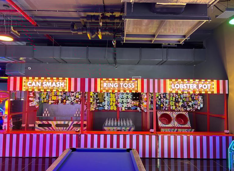 a game room with a pool table and carnival Games