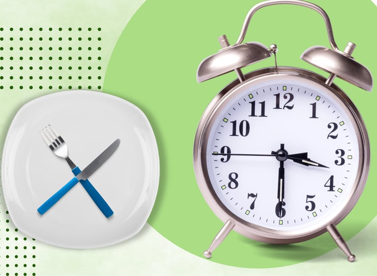 Vintage alarm clock next to an empty plate with a crossed fork and knife illustrating intermittent fasting.