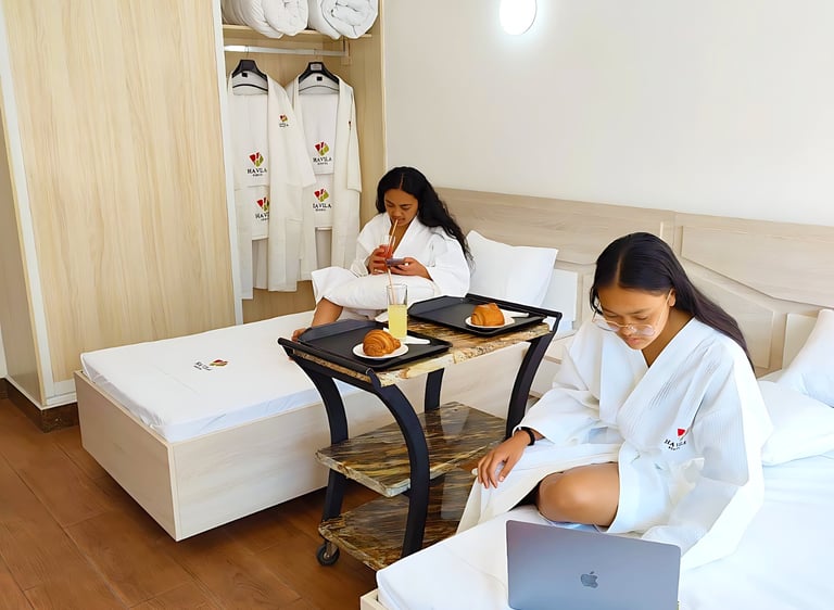 a woman sitting on a bed with a laptop computer