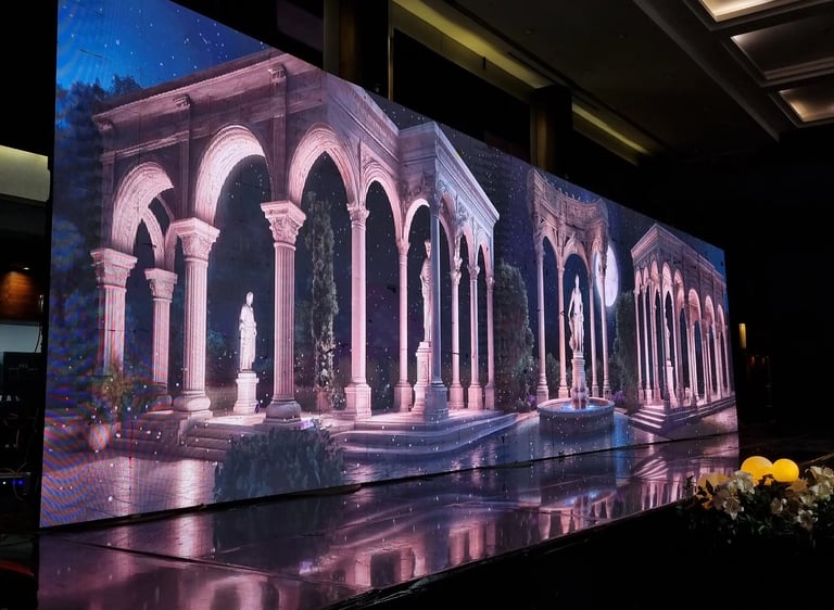 a large led screen of a roman architecture and statues in the middle of a room