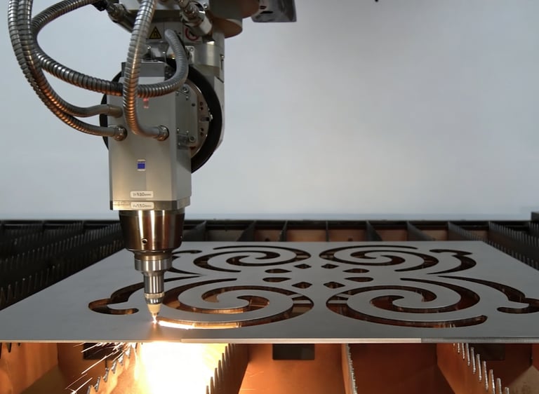 CNC laser cutting machine carving intricate decorative patterns into a metal sheet with sparks.